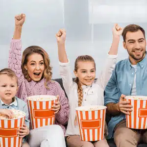 Family enjoys popcorn and laughter, showing one of the top home theater benefits together