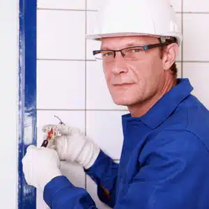 Technician works on faulty outlet, raising questions about when should you rewire a house
