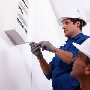 Electricians examining breaker panel to evaluate when should you rewire a house for safety