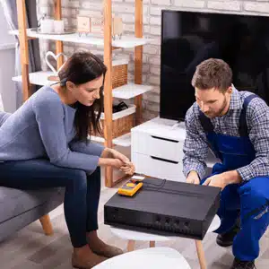Technician assists homeowner with AV system setup, ensuring long-term home theater benefits and reliability