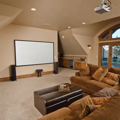 Spacious home theater featuring a large screen, soft lighting, and comfortable sofas for ultimate relaxation
