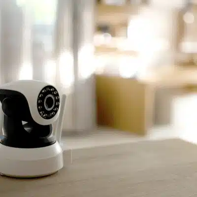 Modern indoor security camera on a table in a bright home, highlighting indoor vs outdoor security cameras