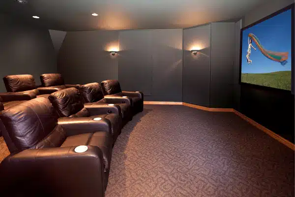 A modern home theater with leather recliners and a large screen for immersive viewing experience