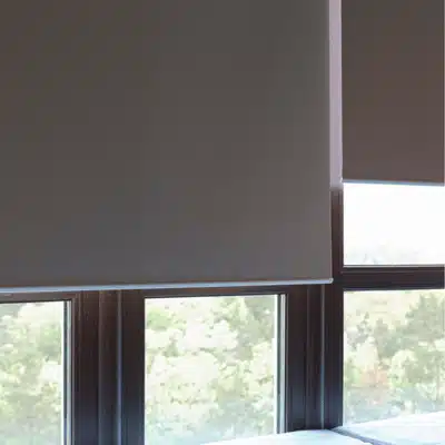 Closeup of roller shade bottom near window frame, showing fabric texture and precise light control