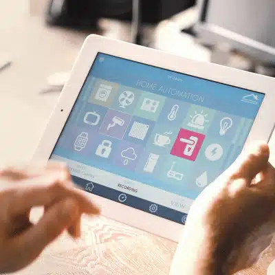 Person uses tablet dashboard to manage devices, illustrating home automation installation services made simple today