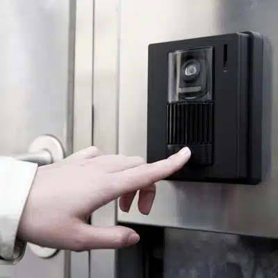 Person presses video intercom button at door while intercom systems for home enable two-way talk