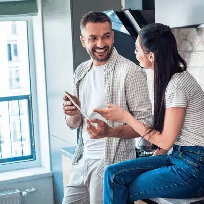 Couple reviews smart home plans on tablet, discussing Home automation installation services for their apartment
