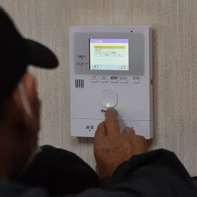 wireless home intercom systems indoor monitor being adjusted by technician to manage visitor calls easily